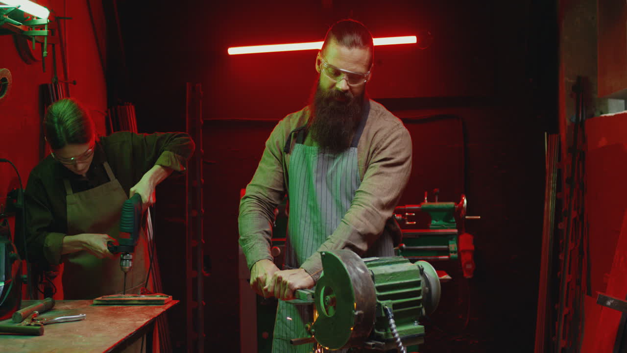trabajadores caucásicos masculinos y femeninos hablando mientras trabajan en el taller