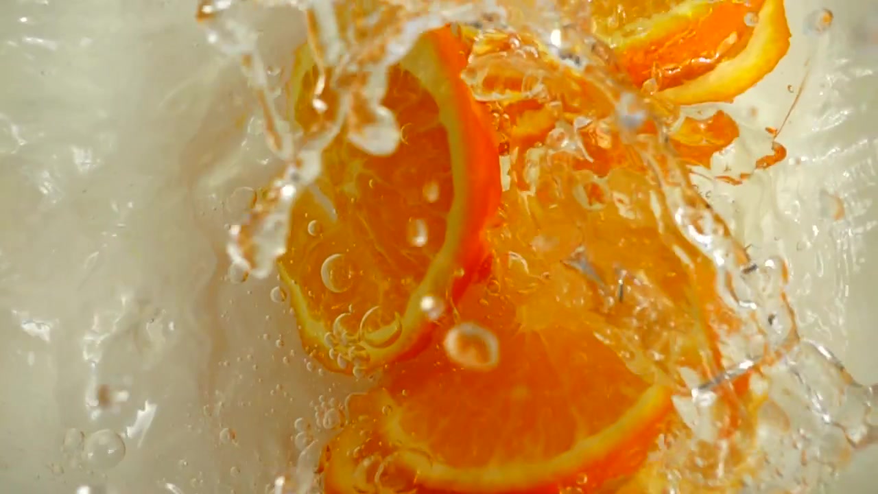Arance che cadono nell'acqua. Rallentatore.