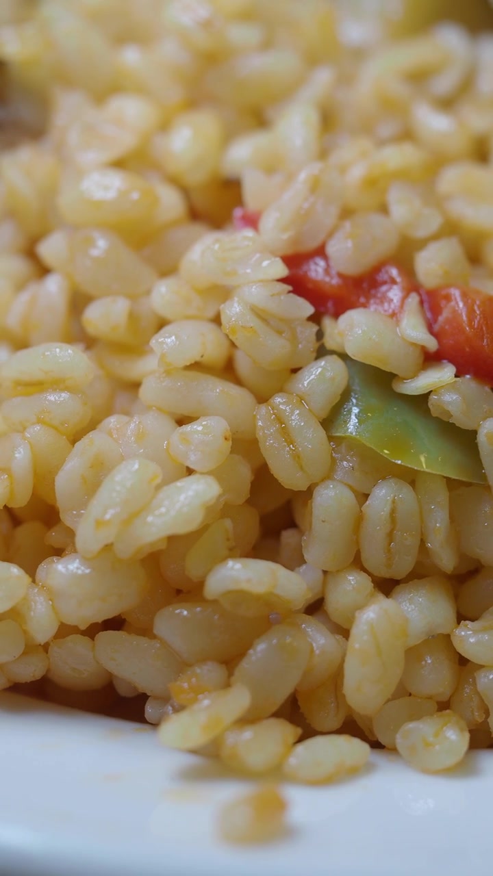 Primo piano di bulgur cotto con pomodoro e peperone