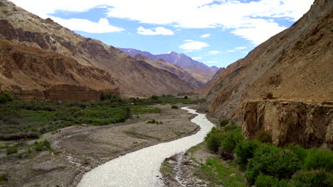 Tilt-up-shot-over-a-river-flows-through-a-canyon-in-the-mountains-on-a-bright-day