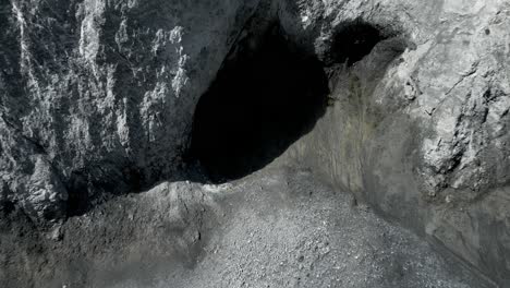 Vista-Aérea-De-Pájaro-Del-Agujero-De-Sombra-Negra-En-El-Cañón-De-La-Montaña-Ruinaulta