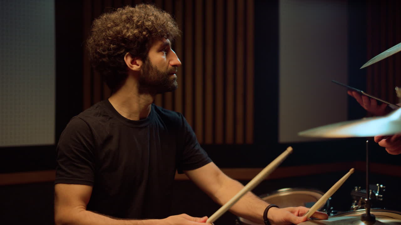 Drummer man hitting drum cymbal in concert hall. Artist speaking in studio.