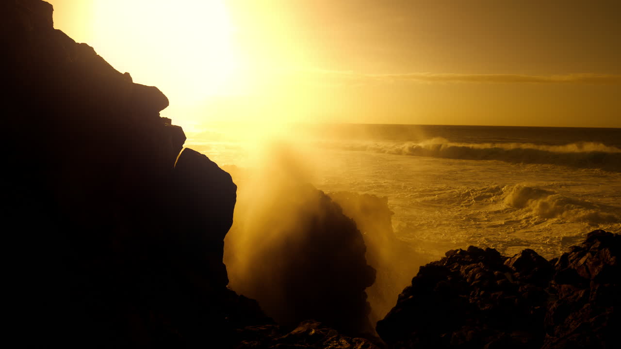 Sunset Over Rocky Coastline with Powerful Waves