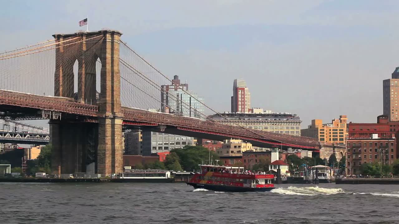페리는 뉴욕시의 브루클린 다리 아래를 통과합니다.