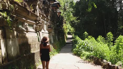 hermosa chica con un sombrero marrón va a lo largo del templo