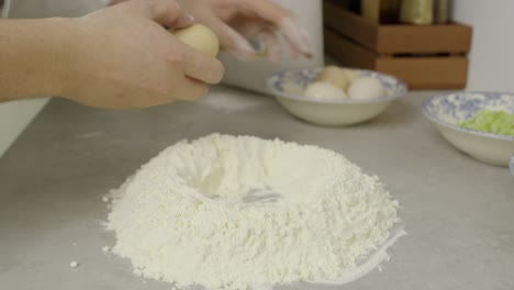 chef prepares flour and eggs for mixing on kitchen cooking table