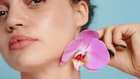 face, flower and woman in studio for beauty