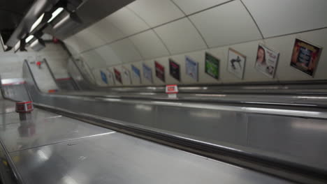 empty escalators in london underground metro station during covid-19 virus pandemic outbreak and lockdown in england uk, slow motion