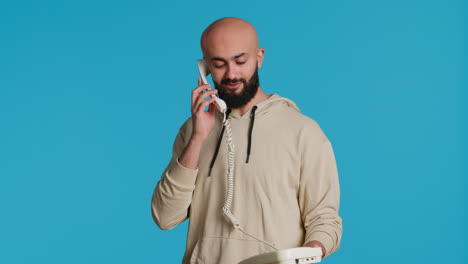 muslim adult taking call on a landline phone in studio