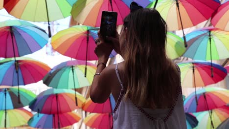 girl taking photos of colored umbrellas in bucharest