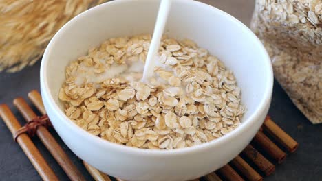 pouring milk on a bowl of oatmeal