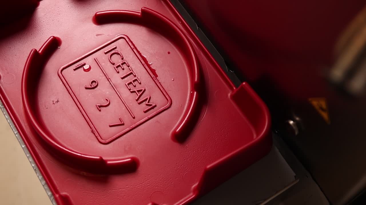Primo piano di vassoio di plastica rosso con scritta ICETEAM in rilievo