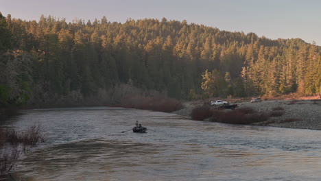 people in a boat rowing and fishing on smith river in california