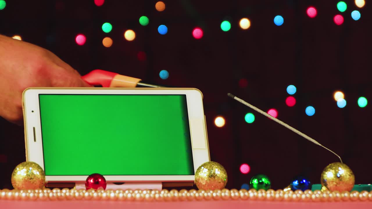 새해의 비디오 스크린 세이버 태블릿은 녹색 스크린과 불타는 스파클러를 가지고 있습니다.