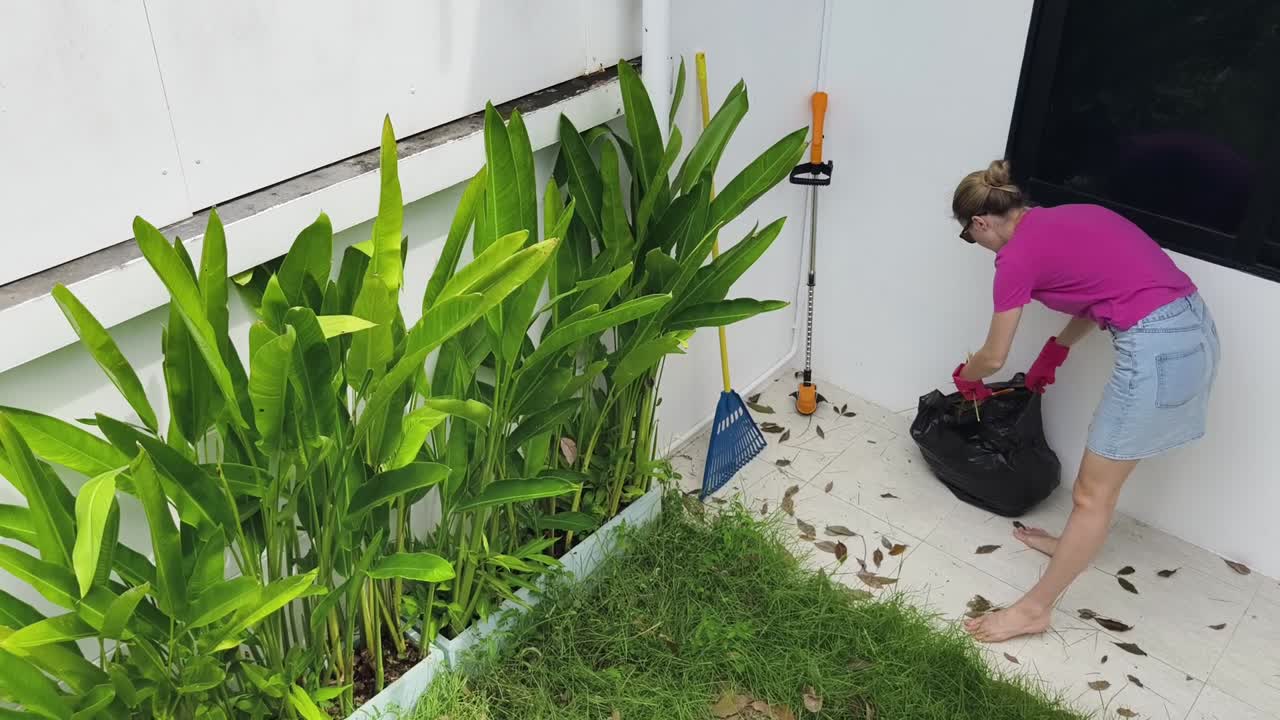 una mujer limpiando su jardín.