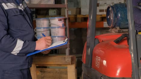Warehouse Worker Inspecting Forklift