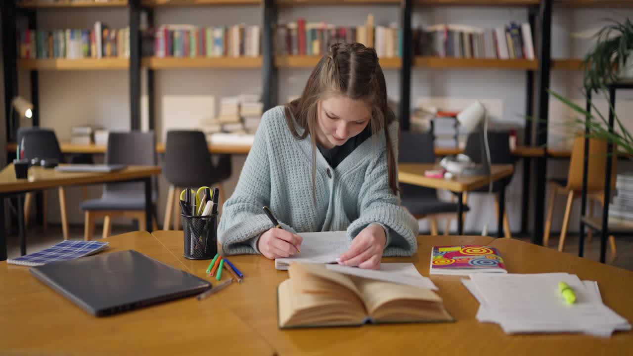 un adolescente estudiando en una biblioteca