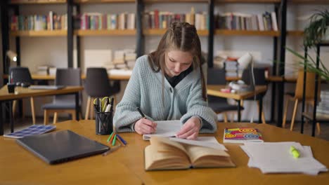 un adolescente estudiando en una biblioteca