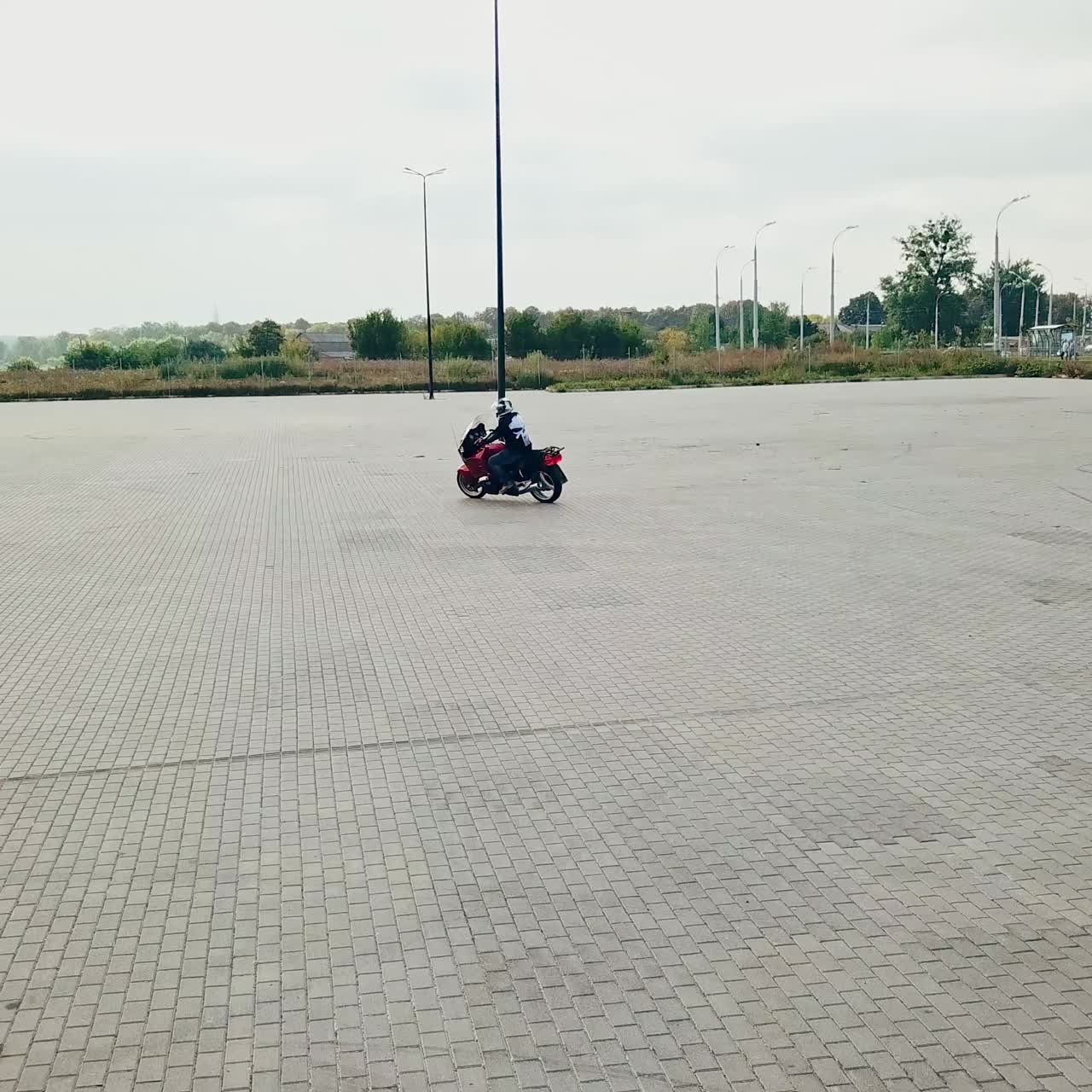 Motorcyclist on motorbike in parking