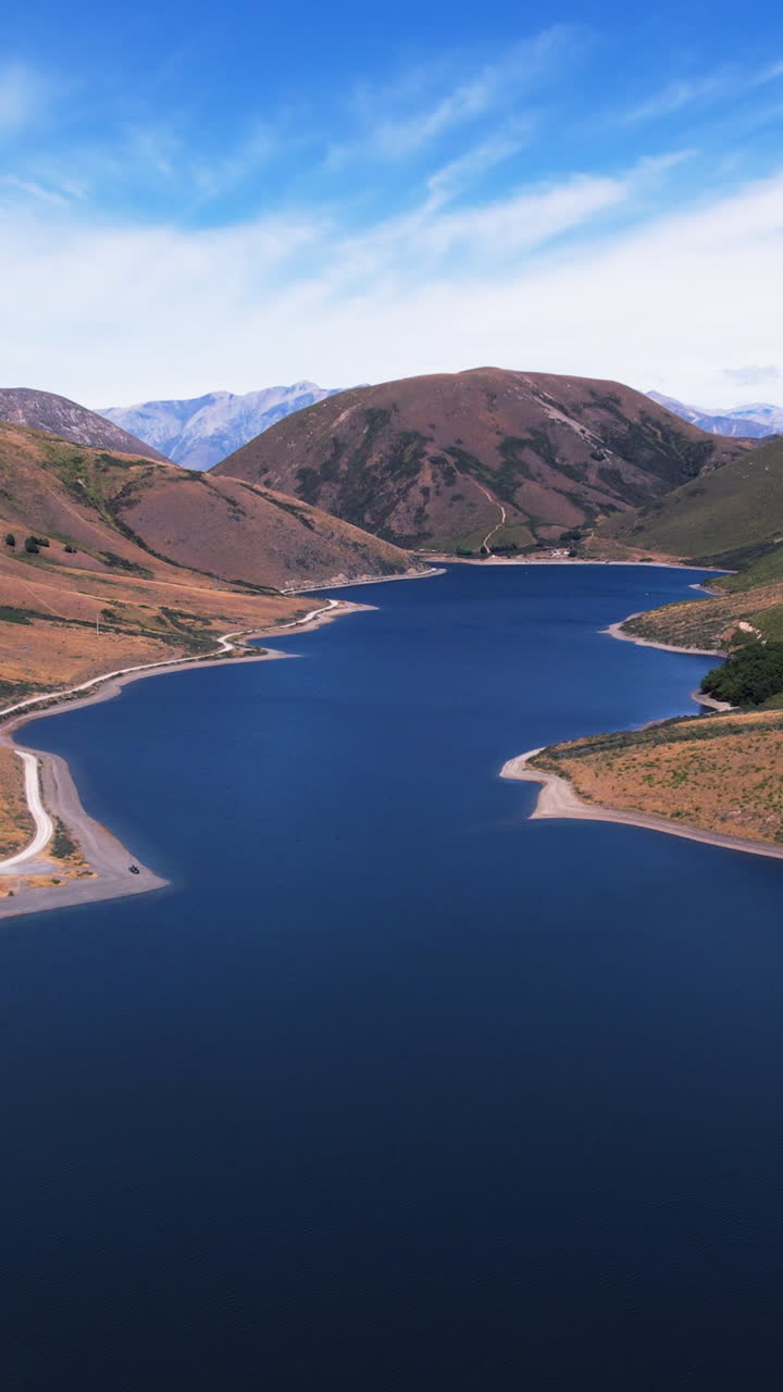 Vertical drone shot backwards over Lake Lyndon, sunny day in New Zealand