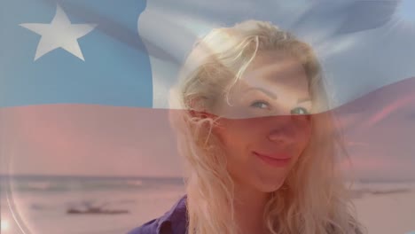 video compuesto de la bandera de texas ondeando sobre el retrato de una mujer caucásica sonriendo en la playa