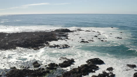 4K-drone-flight-over-rocky-California-coast-at-Monterey-Bay-with-tide-pools-and-seagulls-visible-below