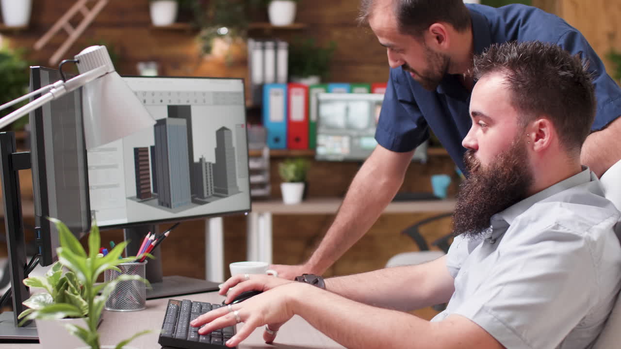 Two men working in an office on a computer