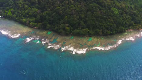 Panama-Tropische-Palme-Küstenwildnis-Luftbild-Schwenken-über-Korallenriff-Türkisfarbenes-Wasser