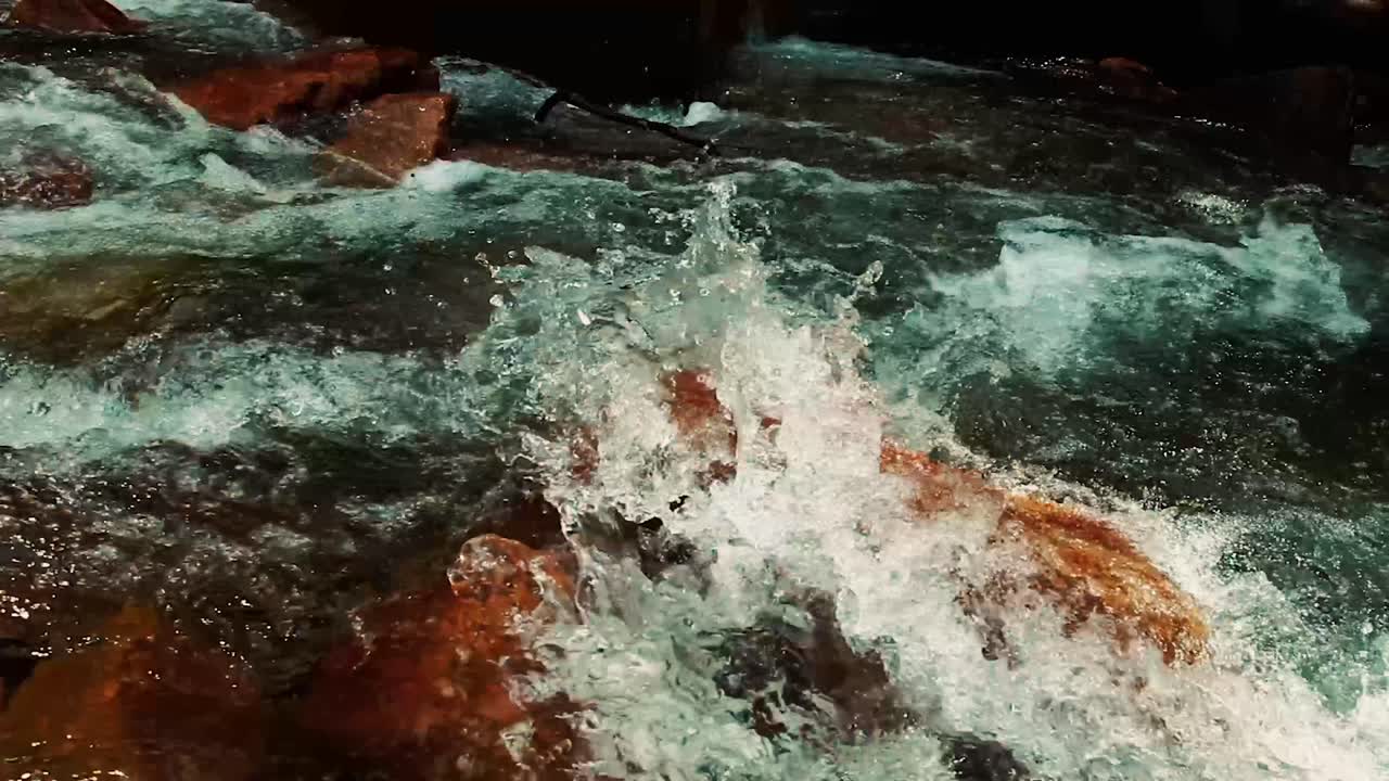 Rushing water over big boulders on a cold winter day