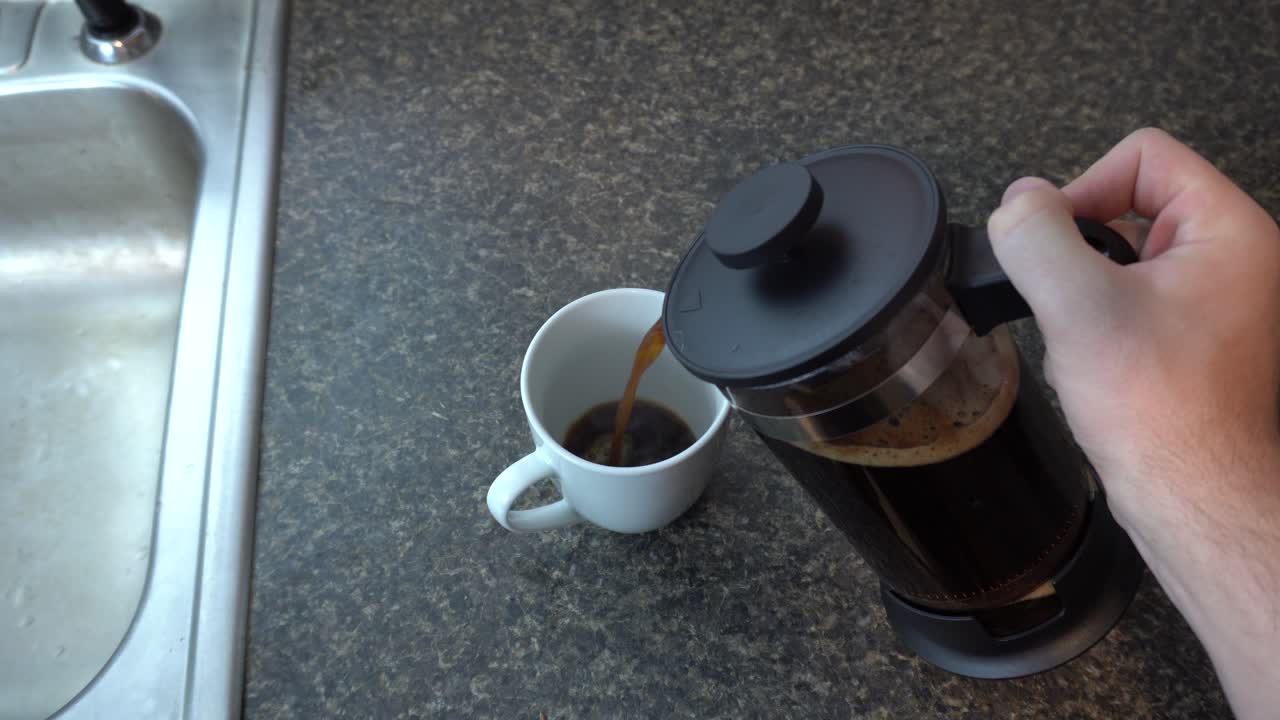 verter café recién hecho de una cafetera de prensa francesa en una taza