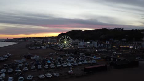 drone captures low-altitude parallax of boats and ferris wheel on eastbourne beach at dusk