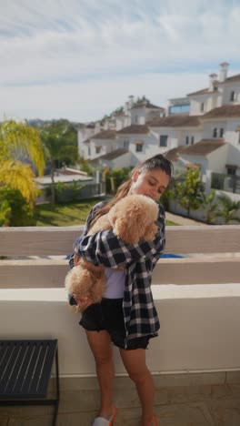 girl hugging a dog on a balcony