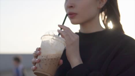 woman enjoying iced coffee outdoors