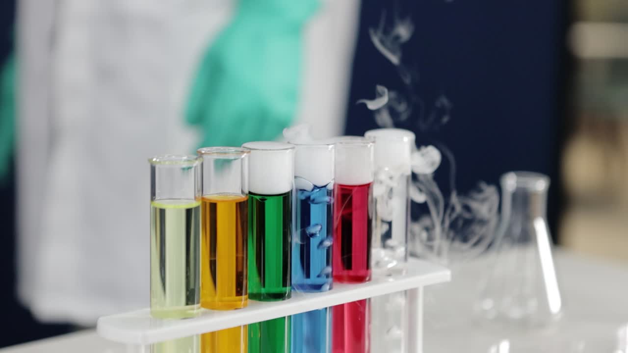 en una exhibición metódica, un científico observa de cerca los tubos de ensayo burbujeantes, reflejando la naturaleza meticulosa de la investigación y la danza dinámica de las interacciones químicas en progreso