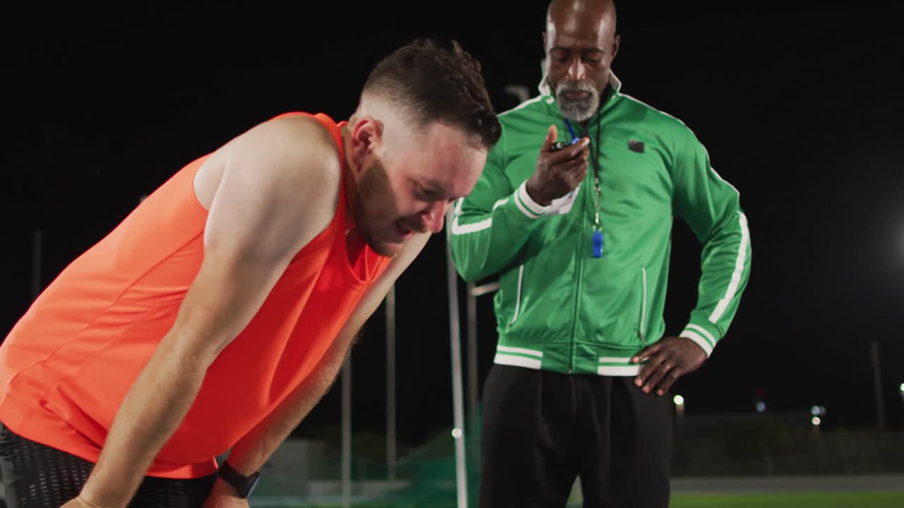 다양한 남성 코치와 피곤한 장애인 남성 선수가 이야기하고 있습니다.