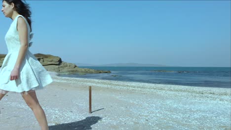 Pretty-girl-in-white-dress-walk-on-the-beach-4