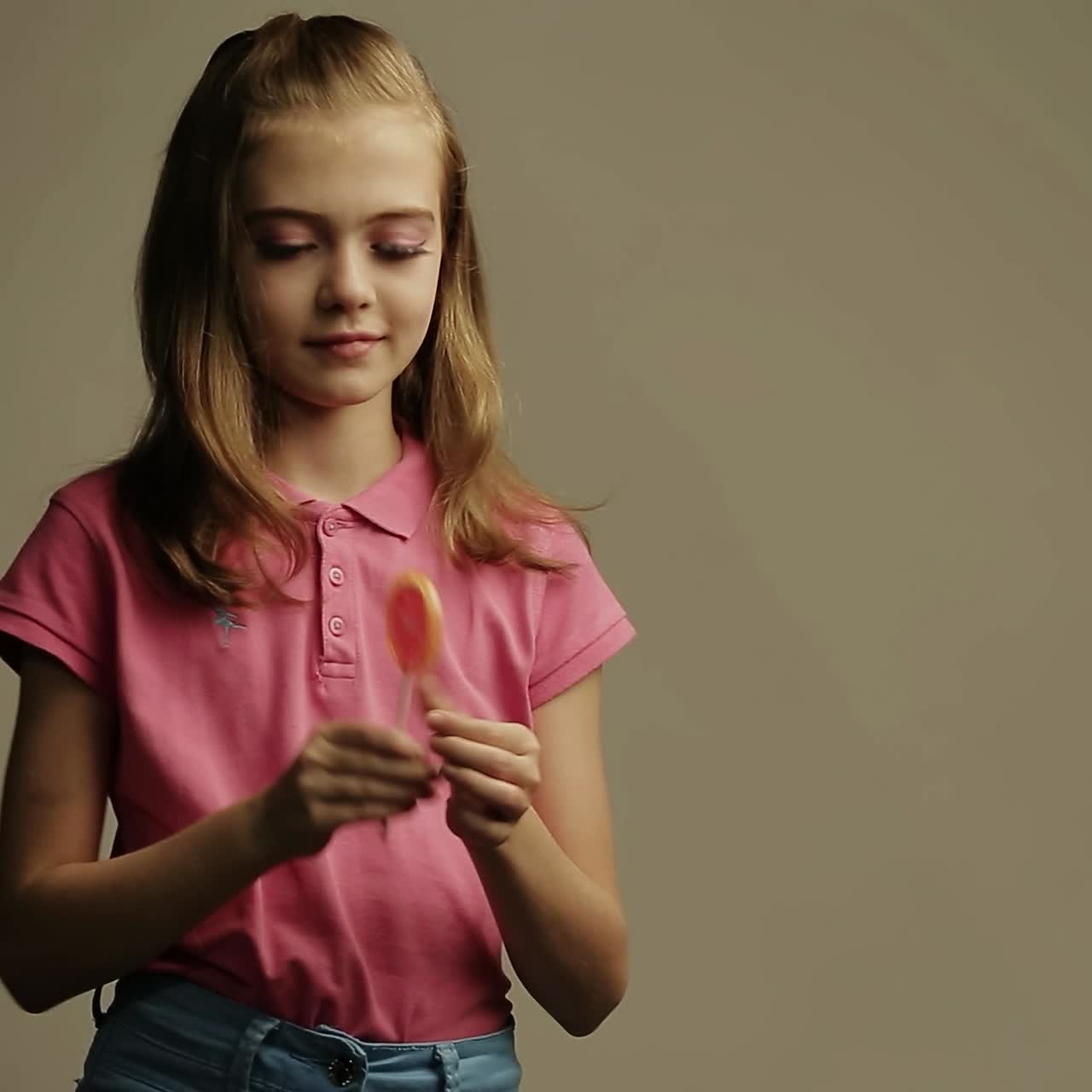 una chica lamendo caramelos de piruleta