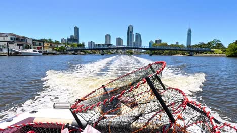 boat travels with crab pot near city skyline