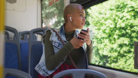 mixed race woman taking the bus and observing outside