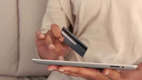 Woman-using-tablet-pc-on-couch