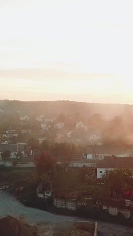air above the city is filled with smoke after a fire from drought on the background of sunset. aerial view vertical video