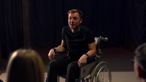 a man in a wheelchair tells the people standing in front of him