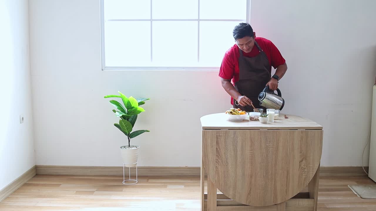 Chef pouring warm water into a bowl preparing delicious healthy meal in a modern bright kitchen