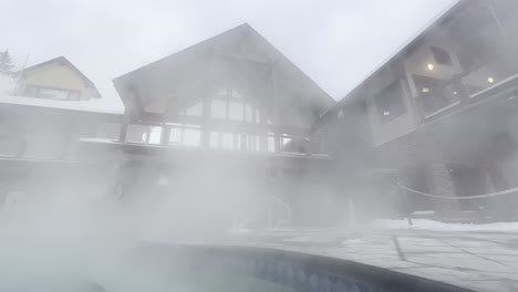 hot steam blowing in the wind off of the hot pools at halcyon hot springs resort british columbia with the lodge