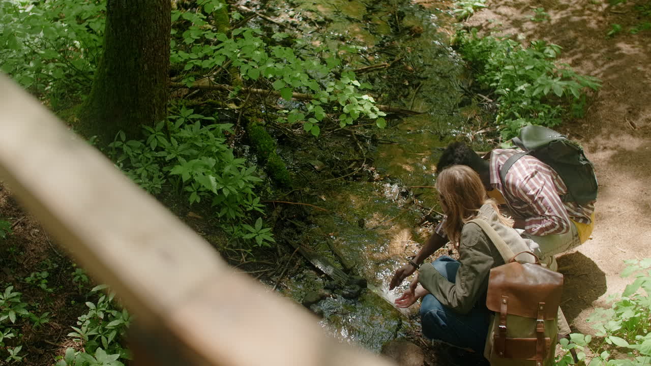 Friends enjoying nature near a stream