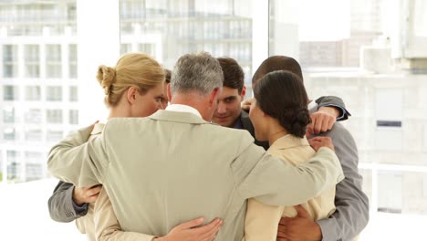 personas de negocios abrazándose en un círculo