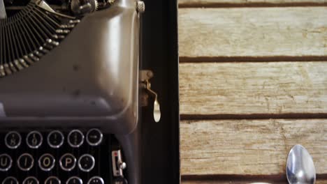 máquina de escribir antigua y café negro en una mesa de madera 4k