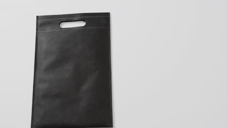 close up of black bag on white background, copy space, slow motion