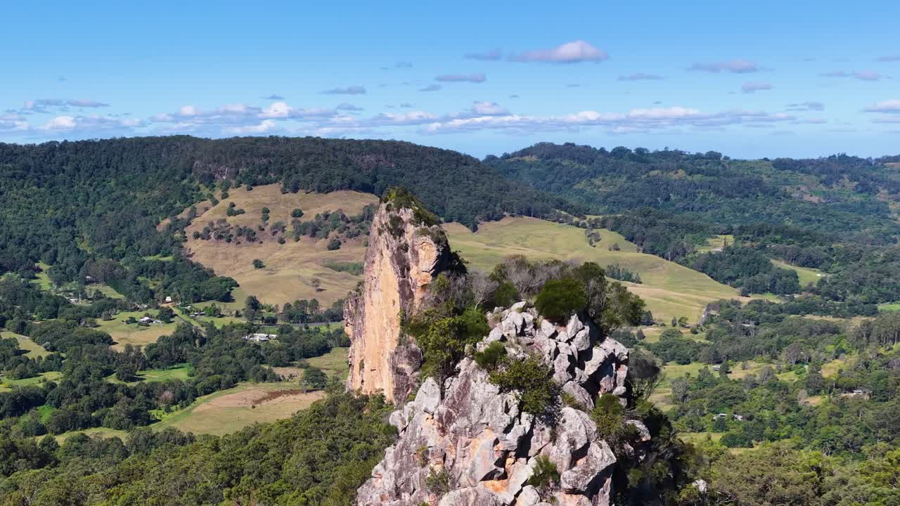 Panoramic view of Nimbin Rocks with lush greenery and clear skies, showcasing natural beauty and geological formations