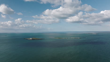 Antena-4k-Del-Faro-De-La-Isla-Farne,-Reino-Unido-En-Una-Tarde-Soleada